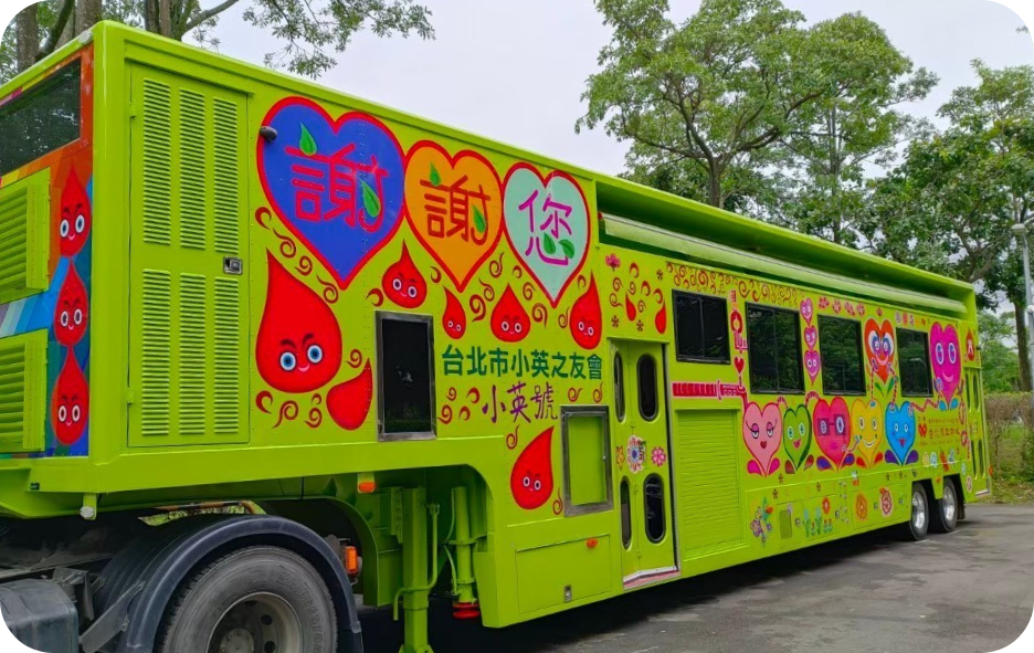 The image features the 'Xiao Ying', a towed electric blood donation vehicle currently stationed at Da'an Forest Park, significantly reducing carbon emissions with an external power source.